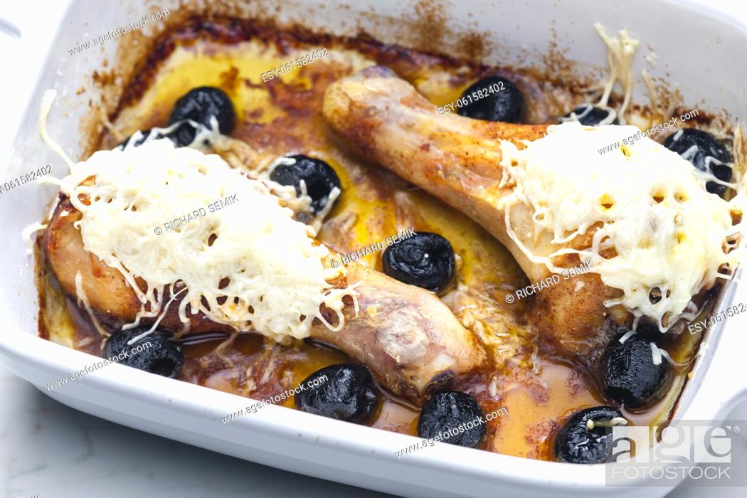 Stock Photo: chicken legs baked with black olives and cheese.