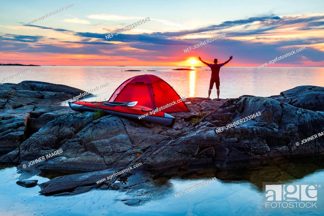 Photo de stock: Man standing on rocks by tent.