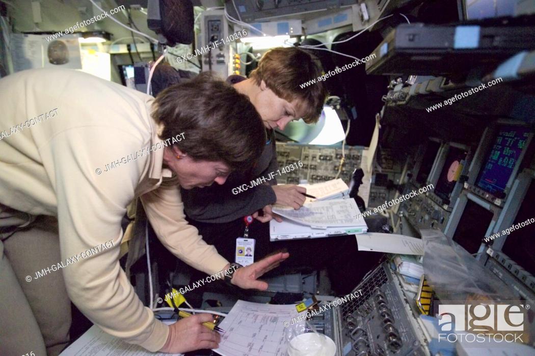 Stock Photo: Astronauts Wendy B. Lawrence (foreground), STS-114 mission specialist, and Eileen M. Collins, commander, discuss flight data during a long duration simulation.