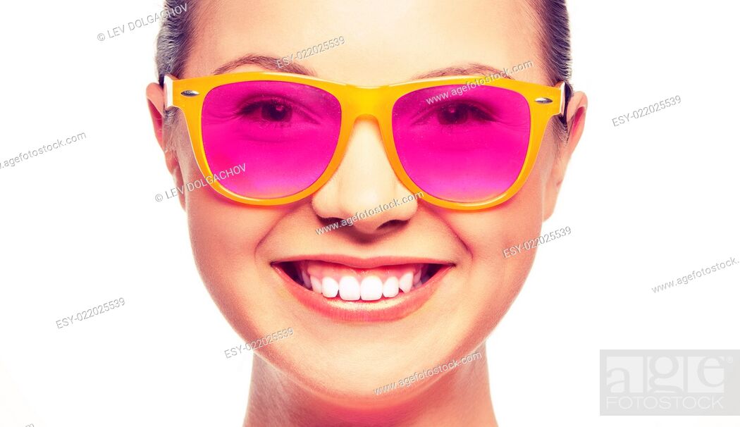 Imagen: happiness, face expressions and people concept - portrait of smiling teenage girl in pink sunglasses.