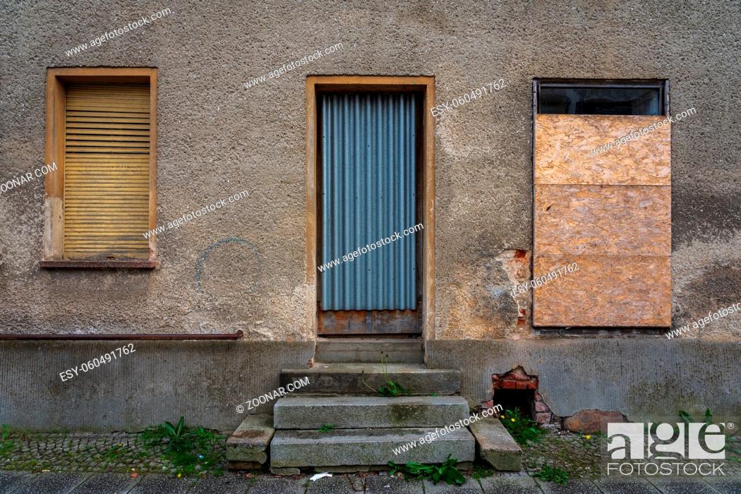 Stock Photo: Boarded up windows and a door in an old building.