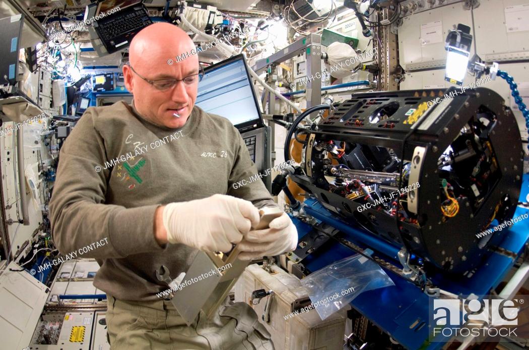 Stock Photo: NASA astronaut Scott Kelly, Expedition 26 commander, works on the Combustion Integrated Rack (CIR) Multi-user Drop Combustion Apparatus (MDCA) in the Destiny.