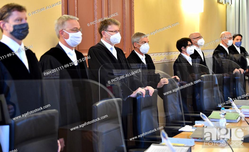 Stock Photo: 11 November 2020, Thuringia, Weimar: Members of the Constitutional Court stand with masks in the Thuringian Constitutional Court at the beginning of the.