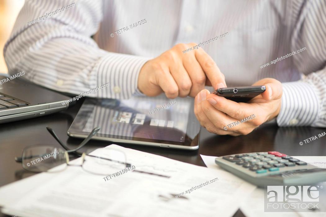 Stock Photo: Man using tablet pc, laptop and smartphone.