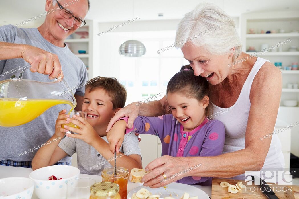 Stock Photo: Grandparents With Grandchildren Making Breakfast In Kitchen.