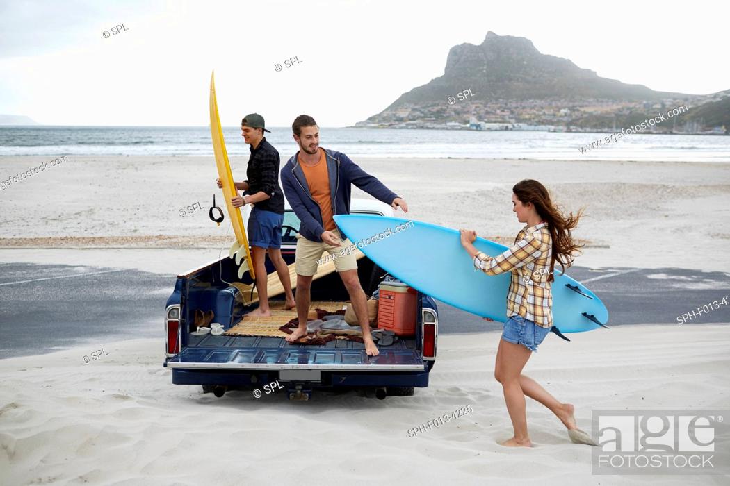 Stock Photo: MODEL RELEASED. Young woman with surfboard on the beach.