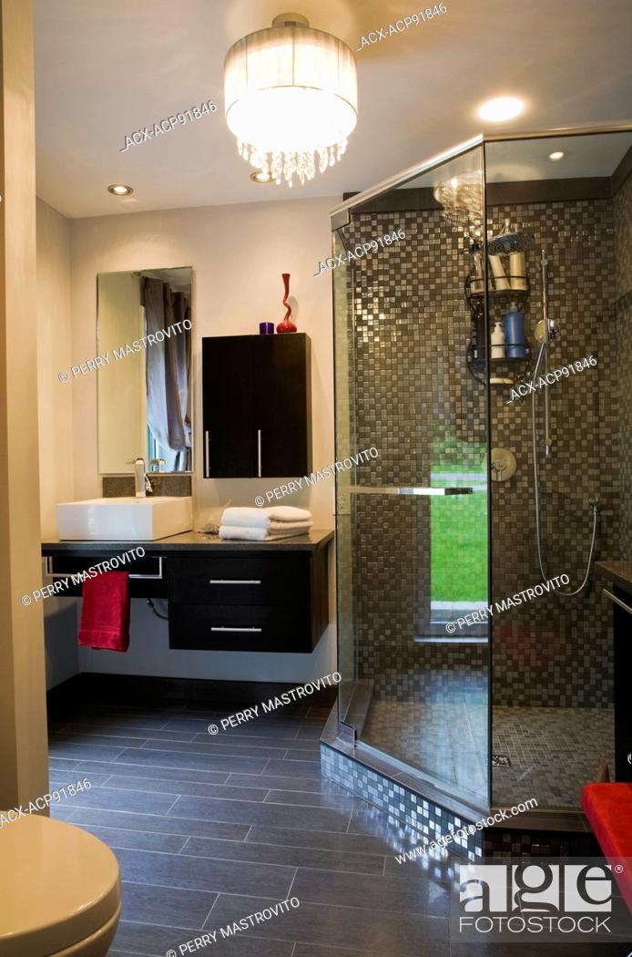 Bathroom With Glass Shower Stall And Black Wooden Cabinets And