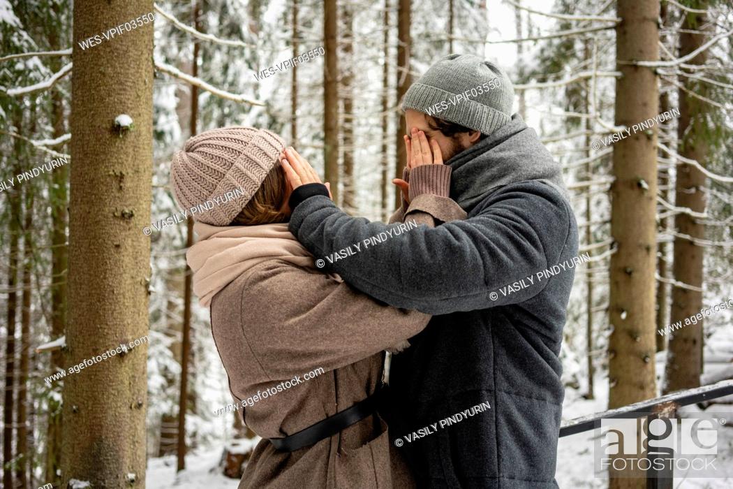 Stock Photo: Young couple covering each other eyes while standing in forest.