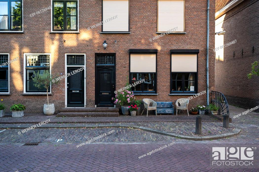 Stock Photo: Zaltbommel, Gelderland, The Netherlands - 07 12 2022 - Traditional house facade with a bench and seats in front.