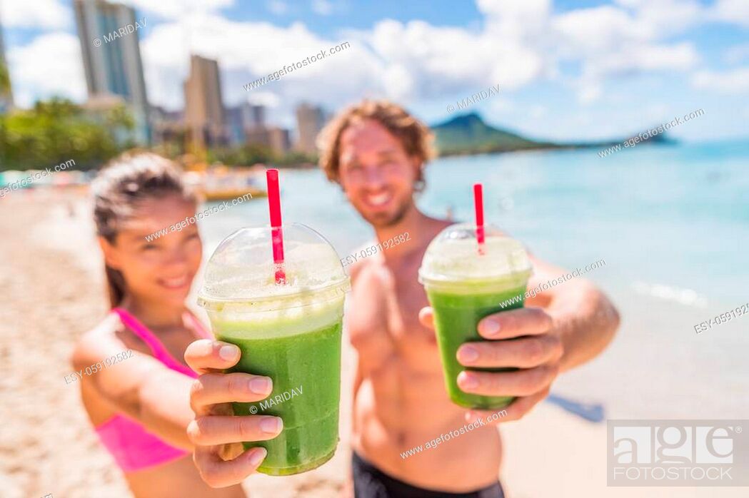 Stock Photo: Fitness couple drinking green smoothie at beach. Man and woman holding vegetable smoothies after running sport fitness training.