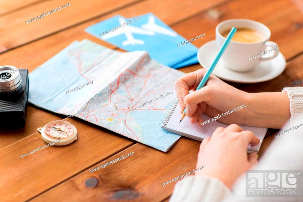 Stock Photo: vacation, tourism, travel, destination and people concept - close up of traveler hands with blank notepad and pencil.