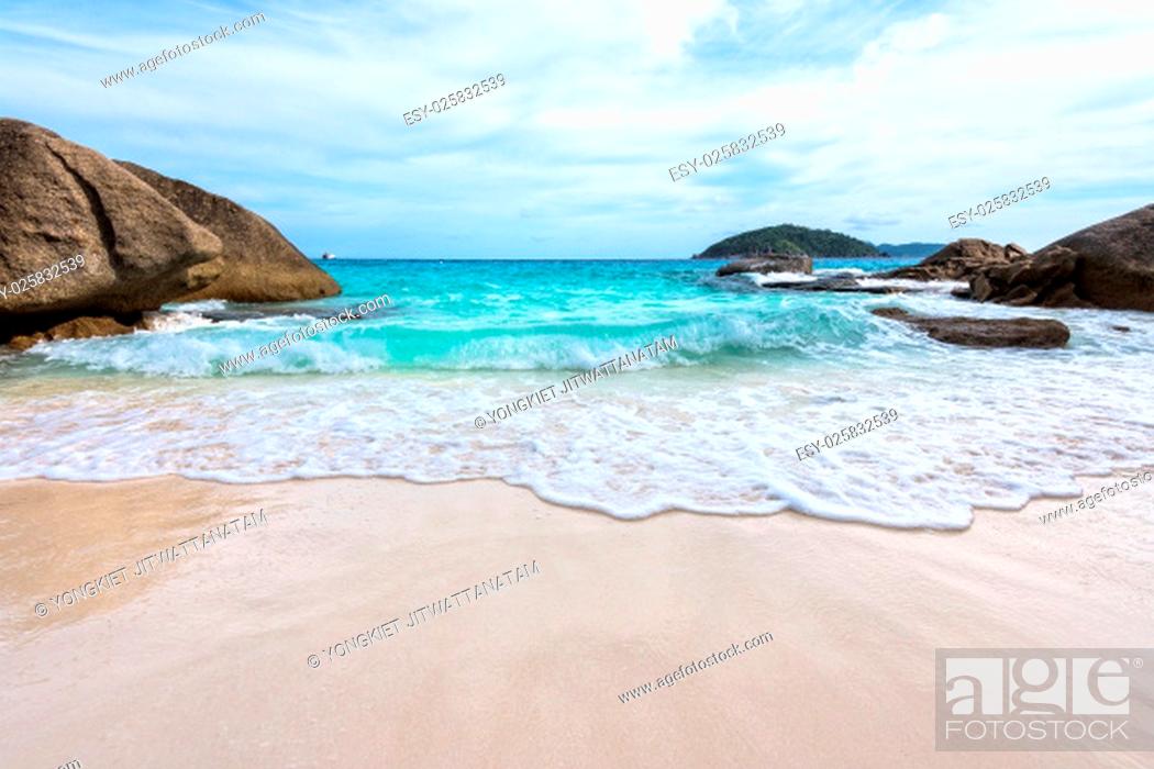 Stock Photo: Beautiful nature of blue sea sand and white waves on small beach near the rocks during summer at Koh Miang island in Mu Ko Similan National Park.