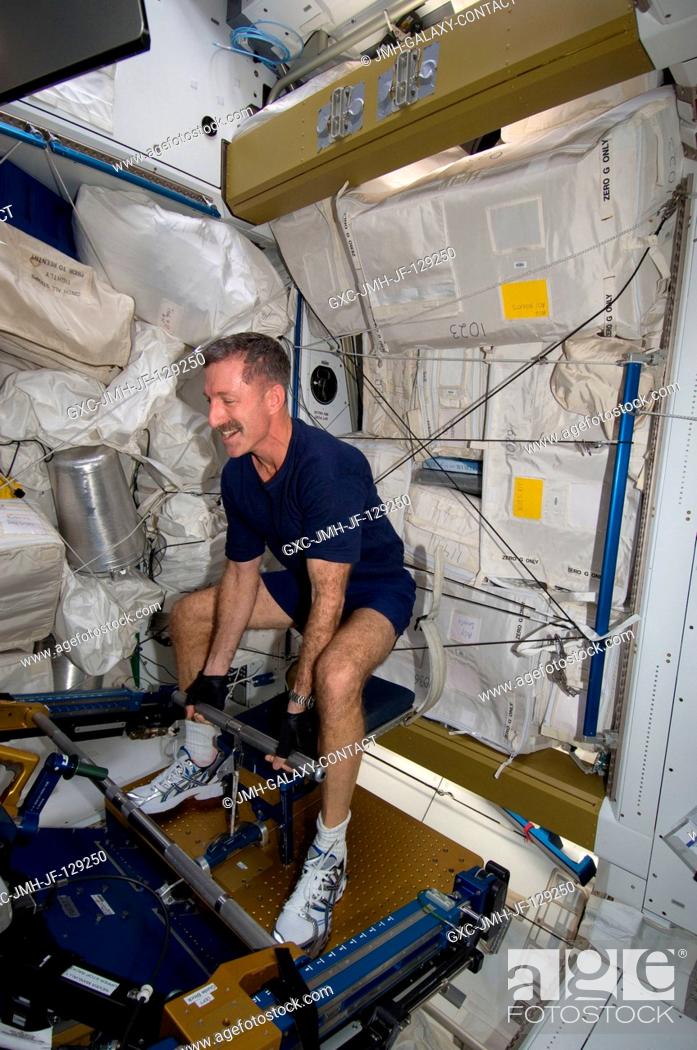 Stock Photo: NASA astronaut Dan Burbank, Expedition 30 commander, uses the short bar for the advanced Resistive Exercise Device (aRED) equipment to perform upper body.