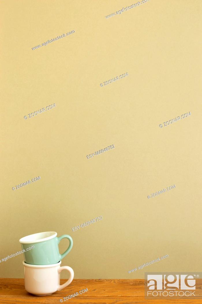 Stock Photo: Stack of mug cup on wooden table. khaki beige background.