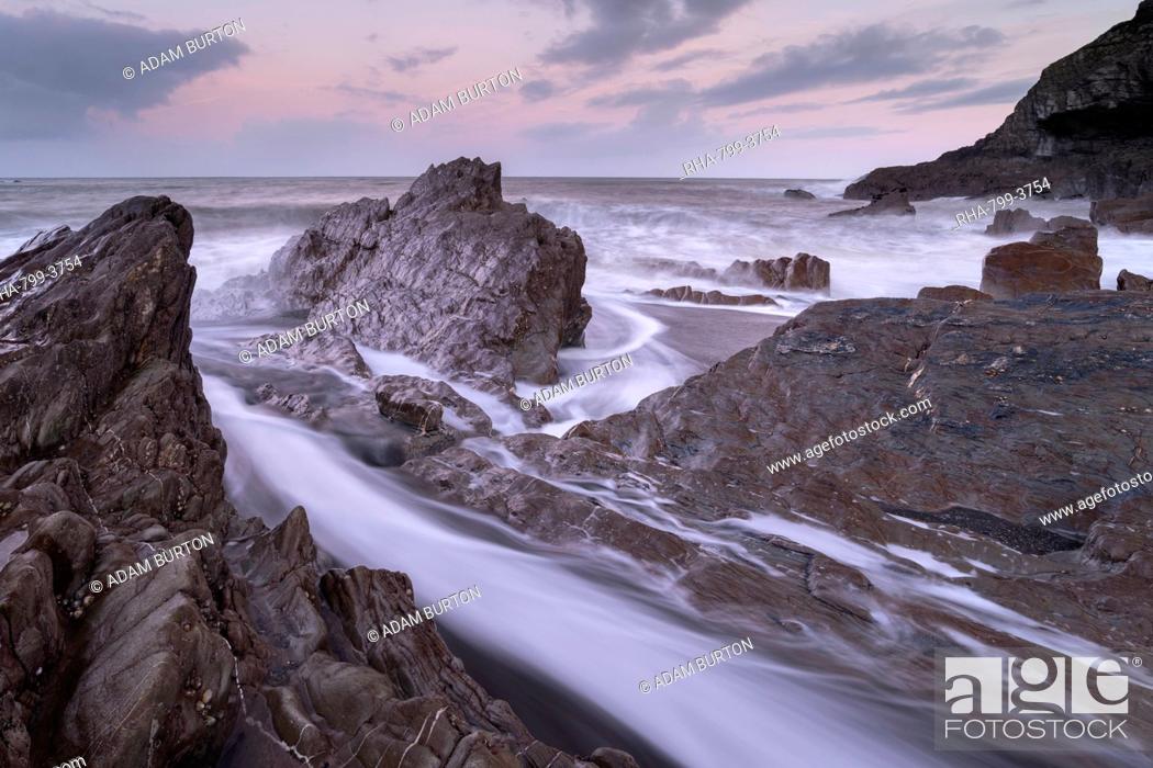 Stock Photo: Waves surge around the jagged rocks on Wildersmouth Beach, Ilfracombe, Devon, England, United Kingdom, Europe.