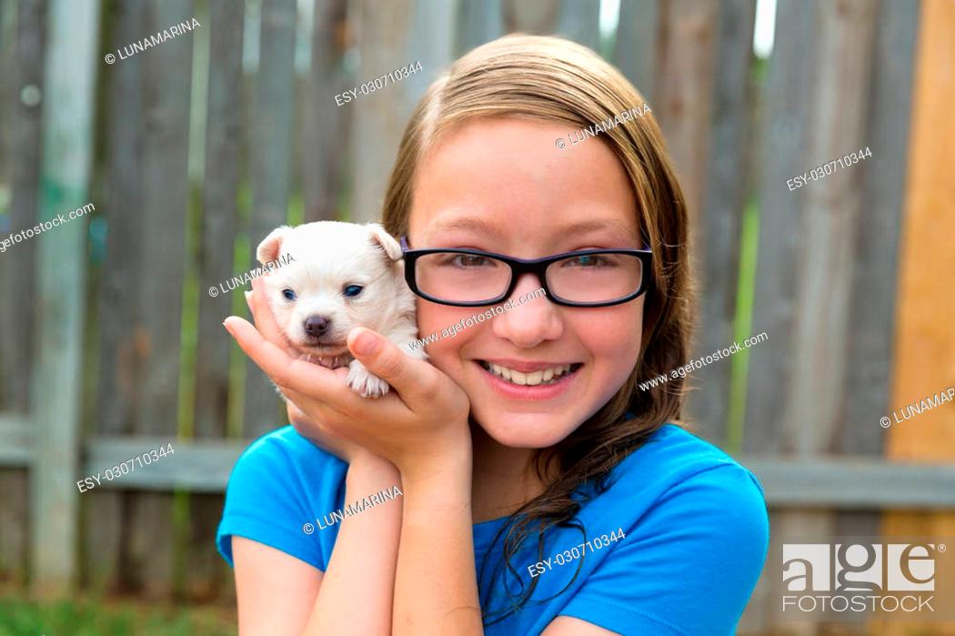 Stock Photo: kid girl with puppy pet chihuahua playing happy with doggy outdoor.
