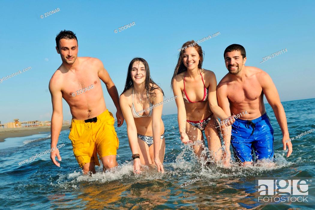 Stock Photo: happy young people group have fun run and jump on beach beautiful sand beach.