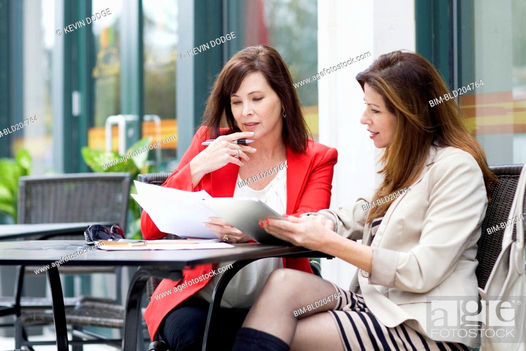 Stock Photo: Caucasian businesswomen working at cafe.