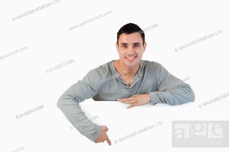 Stock Photo: Young male pointing at banner below him.