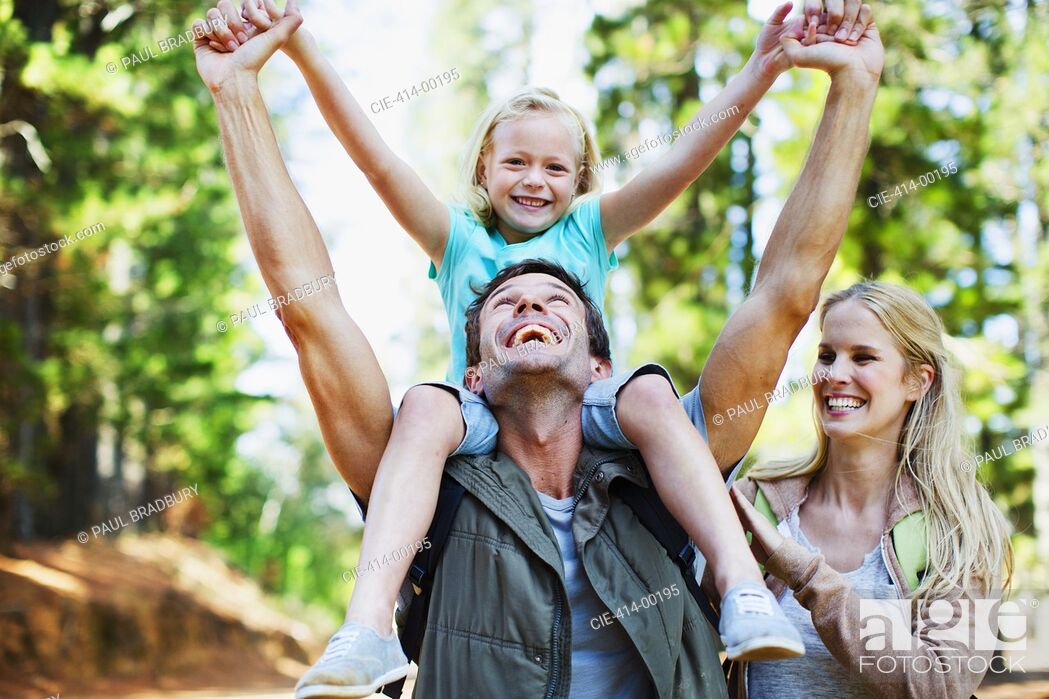 Stock Photo: Father carrying daughter on shoulders in woods.