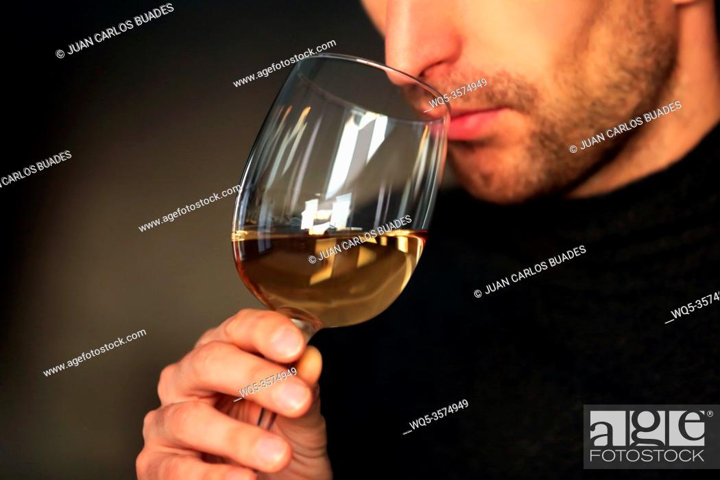 Photo de stock: Man sniffing white wine in a glass, close up.