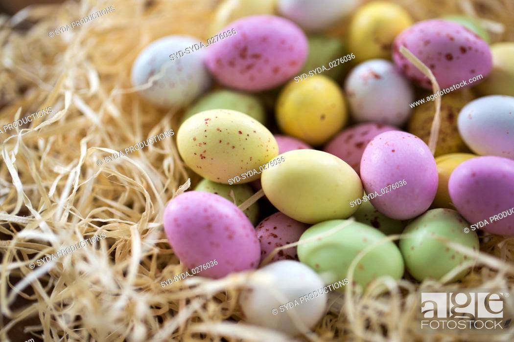 Stock Photo: close up of easter egg candies in straw nest.