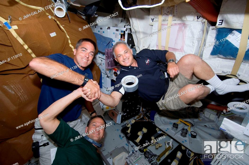 Imagen: Astronauts Christopher Cassidy (left), Dave Wolf (right)and Tom Marshburn (bottom), all STS-127 mission specialists, share a moment shaking hands with one.