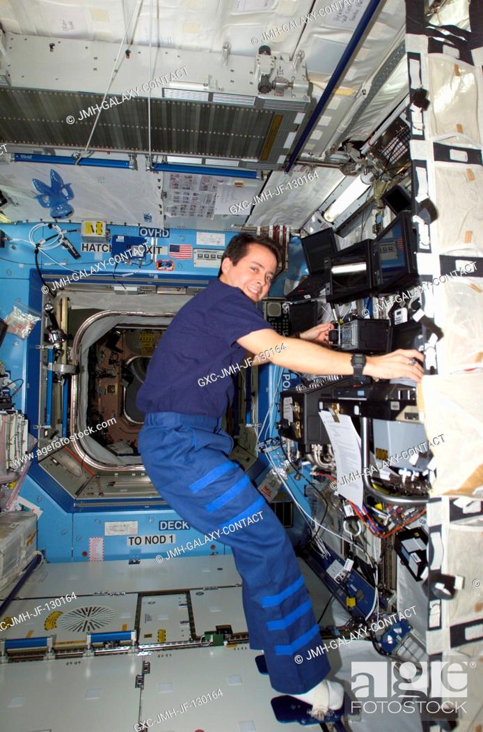 Stock Photo: Astronaut Daniel W. Bursch, Expedition Four flight engineer, works the controls of the Canadarm2, or Space Station Remote Manipulator System (SSRMS) in the.