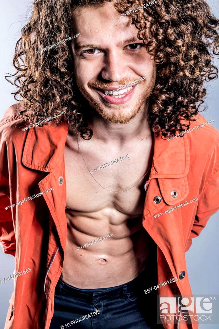 Attractive young man with long ginger curly hair in orange colored coat and  bandana, studio portrait, Stock Photo, Picture And Low Budget Royalty Free  Image. Pic. ESY-047881663 | agefotostock