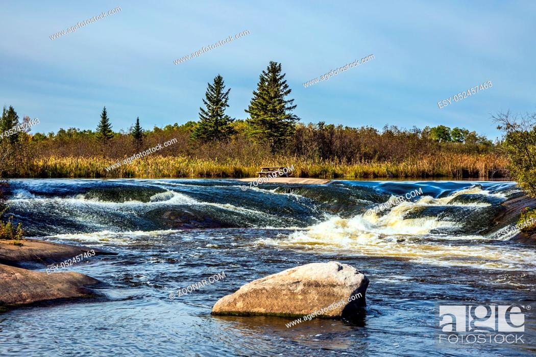 Stock Photo: Foam water rapids on the smooth stones of the Winnipeg River. Old Pinawa Dam Provincial Heritage Park. The concept of travel.