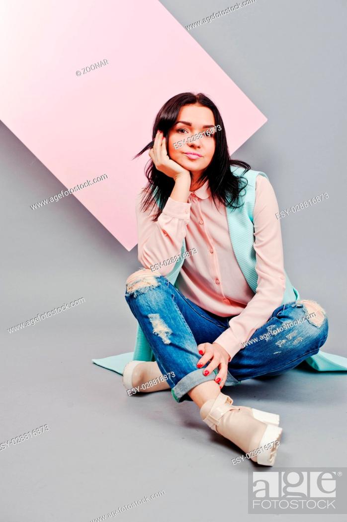 Stock Photo: Full length studio portrait of young girl model at ripped jeans and rose blouse with pink banner board.