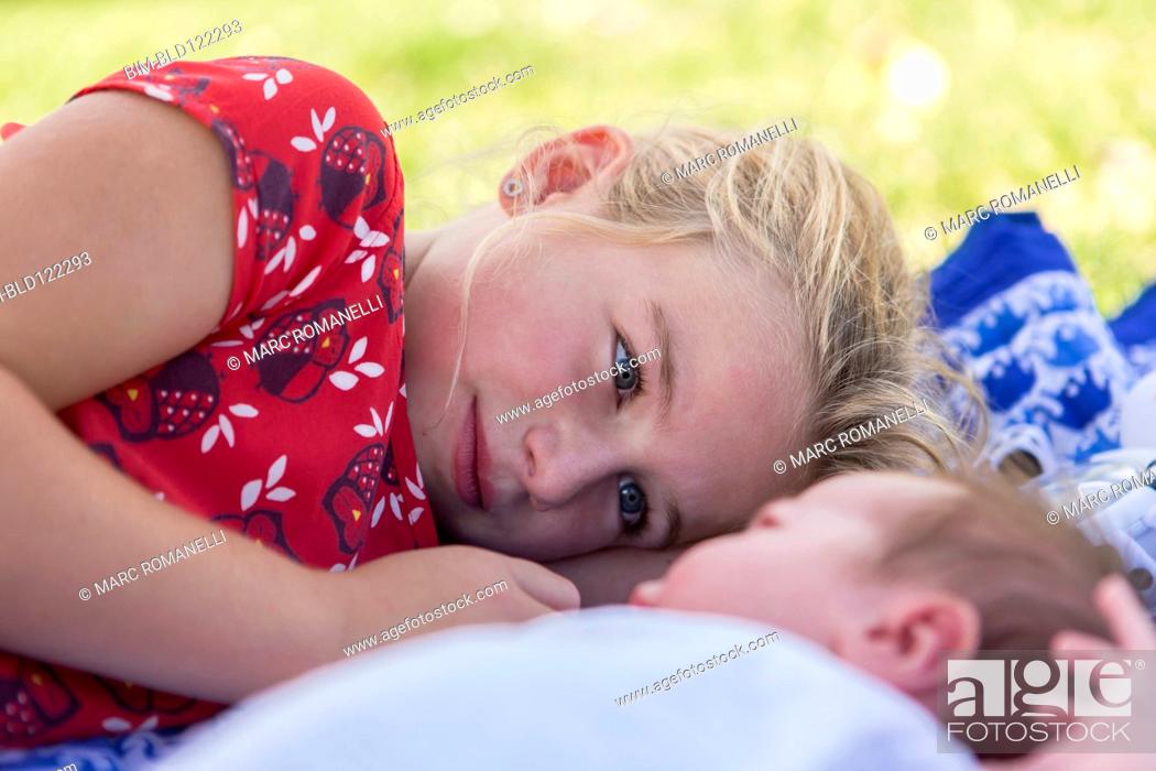 Stock Photo: Caucasian girl laying with newborn baby brother.