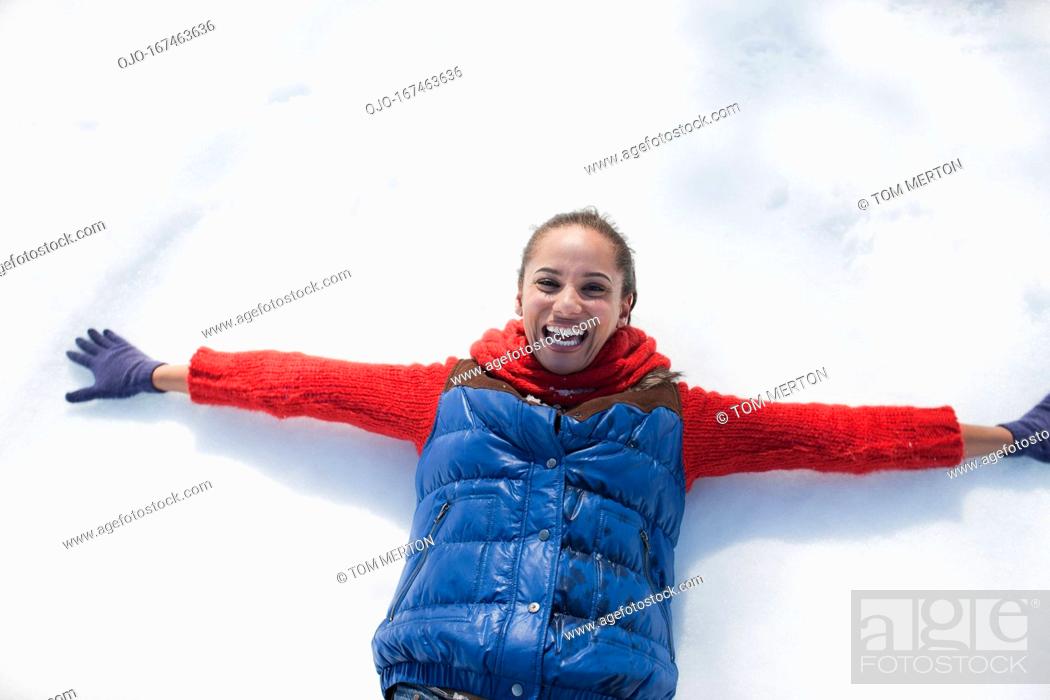 Stock Photo: Smiling woman making snow angels.