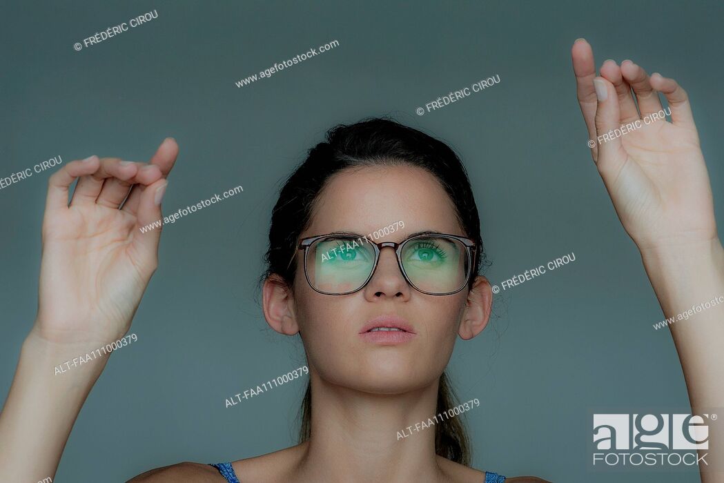 Photo de stock: Young woman gesturing as if using touch screen technology.