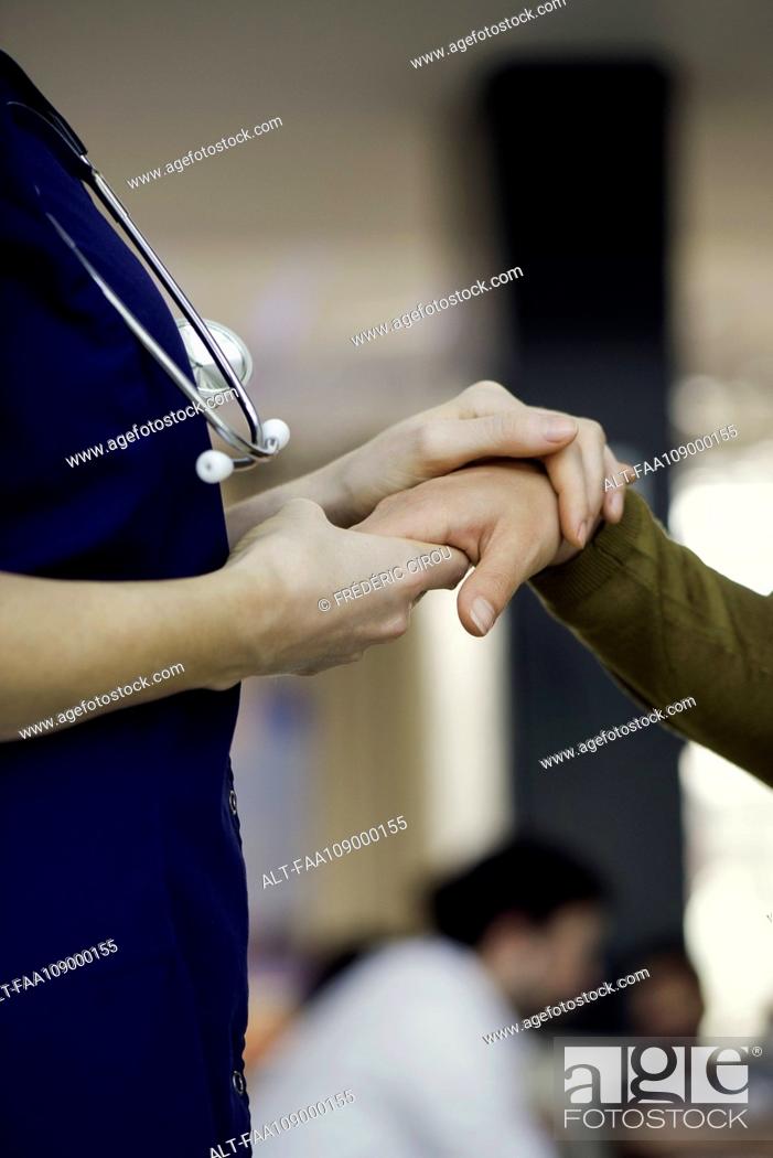 Imagen: Doctor holding patient's hand.