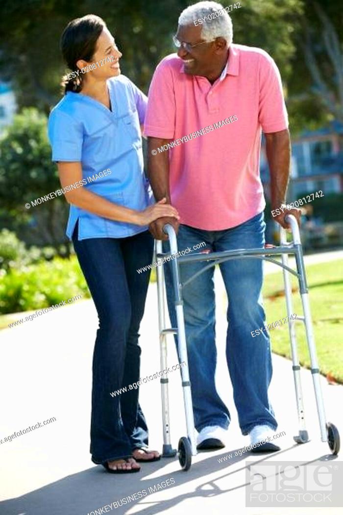 Stock Photo: Carer Helping Senior Man With Walking Frame.