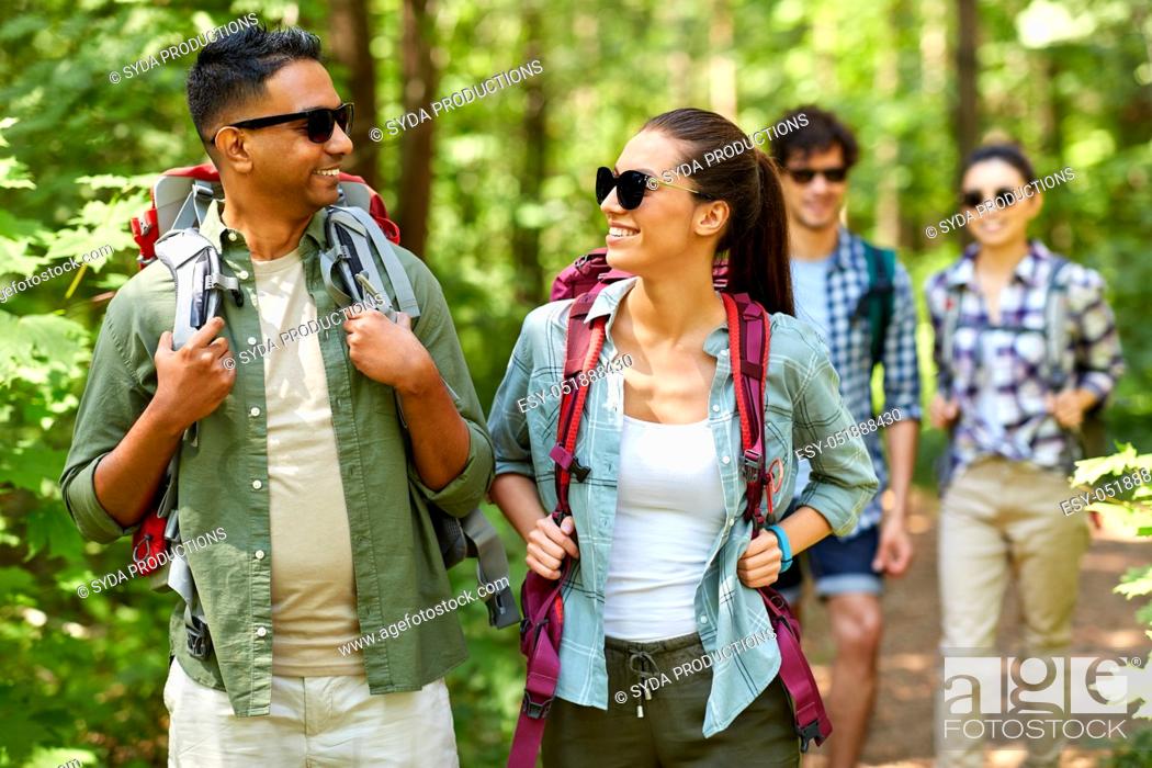 Stock Photo: group of friends with backpacks hiking in forest.