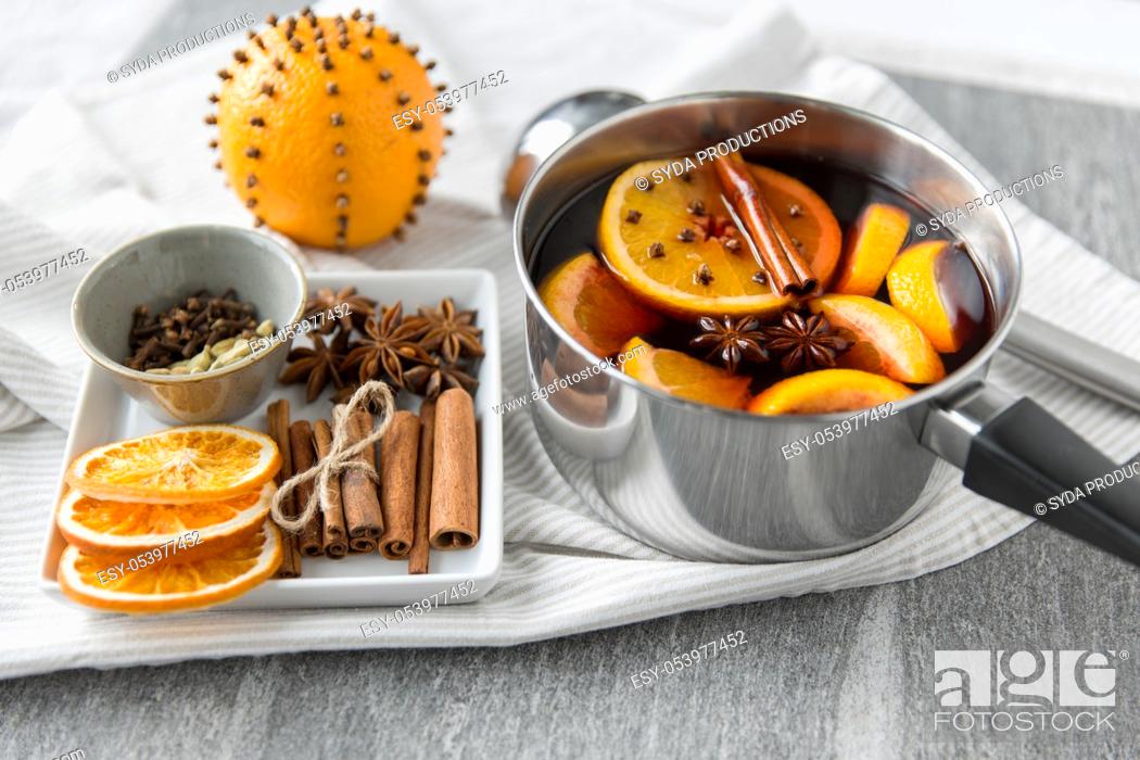 Stock Photo: pot with hot mulled wine, orange slices and spices.
