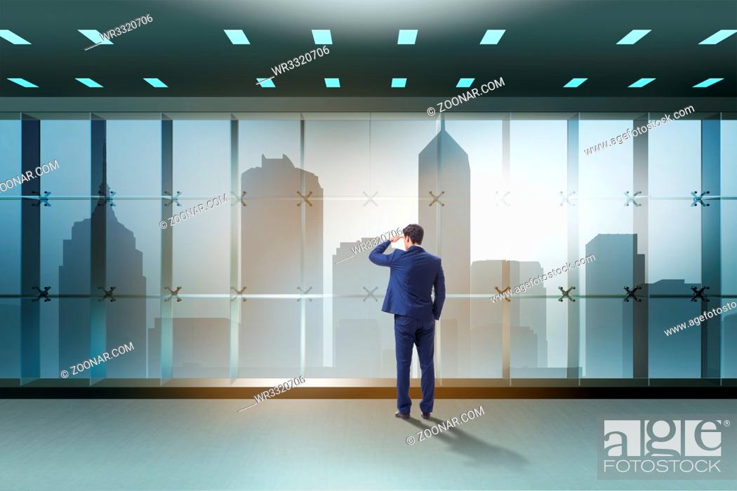 Stock Photo: Businessman in front of office window thinking of new challenges.