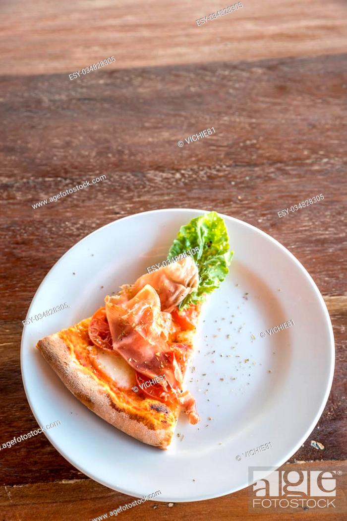 Stock Photo: piece of pizza parma ham and rocket salad.