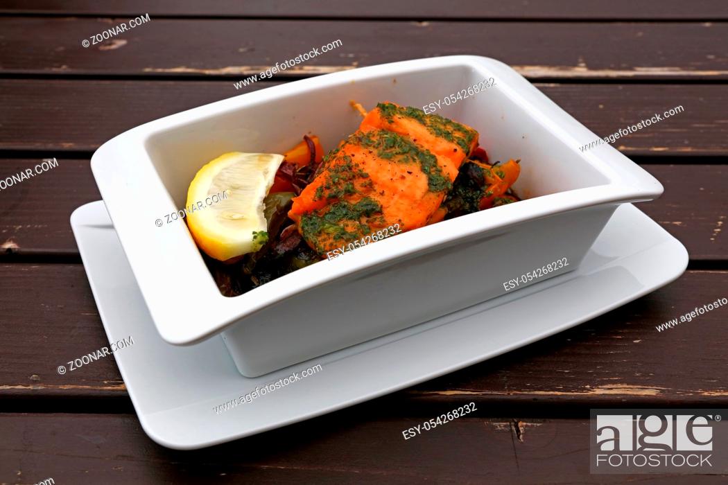 Stock Photo: Close up portion of baked or roasted salmon with vegetables in white bowl over table, elevated top view, directly above.