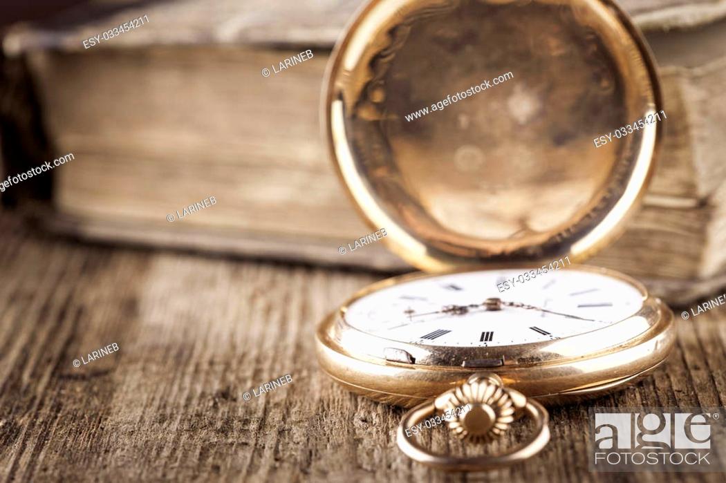 Stock Photo: vintage pocket watch and book on wood still life closeup.