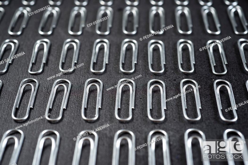 Stock Photo: Paperclips group on a black table.