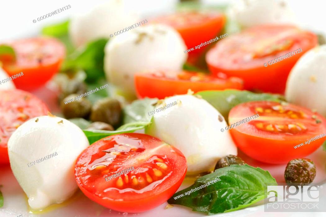 Stock Photo: caprese salad with mini mozzarella balls, tomatoes and capers, closeup photo.