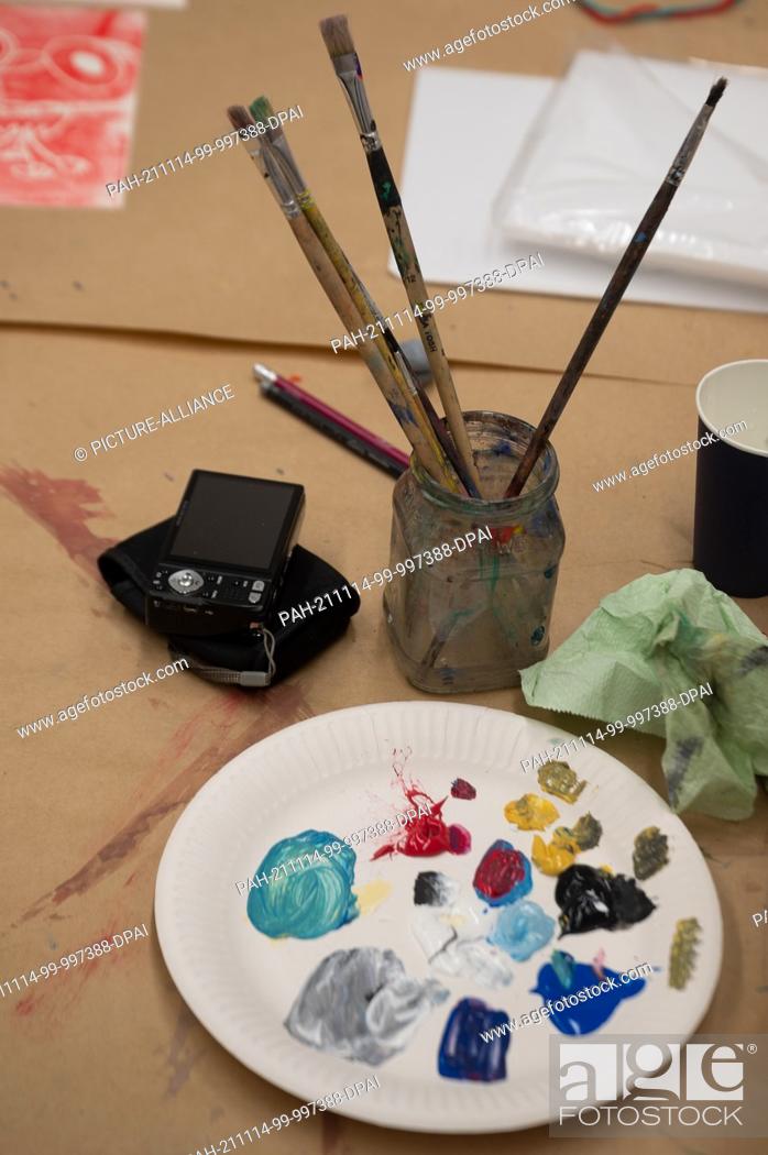 Stock Photo: 11 November 2021, Hessen, Frankfurt/Main: A paper plate with colors lies on a table during an art therapy session. Photo: Sebastian Gollnow/dpa.