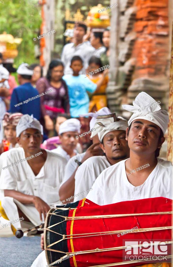 Stock Photo: Musicians play a traditional drum as part of the ceremony at PURA TIRTA EMPUL TEMPLE COMPLEX during the GALUNGAN FESTIVAL - TAMPAKSIRING, BALI.