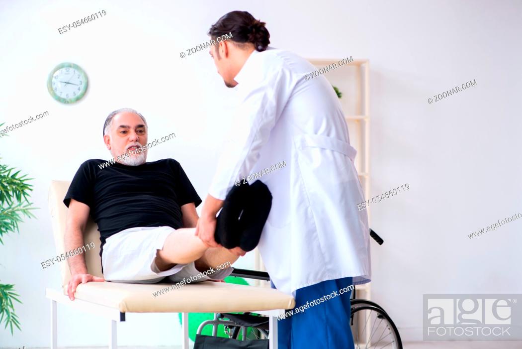 Stock Photo: The old injured man visiting young doctor.