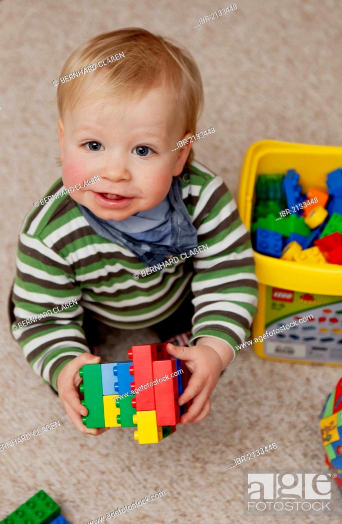 Stock Photo: Young boy, 14 months, playing with colourful plastic Lego Duplo bricks, Germany.