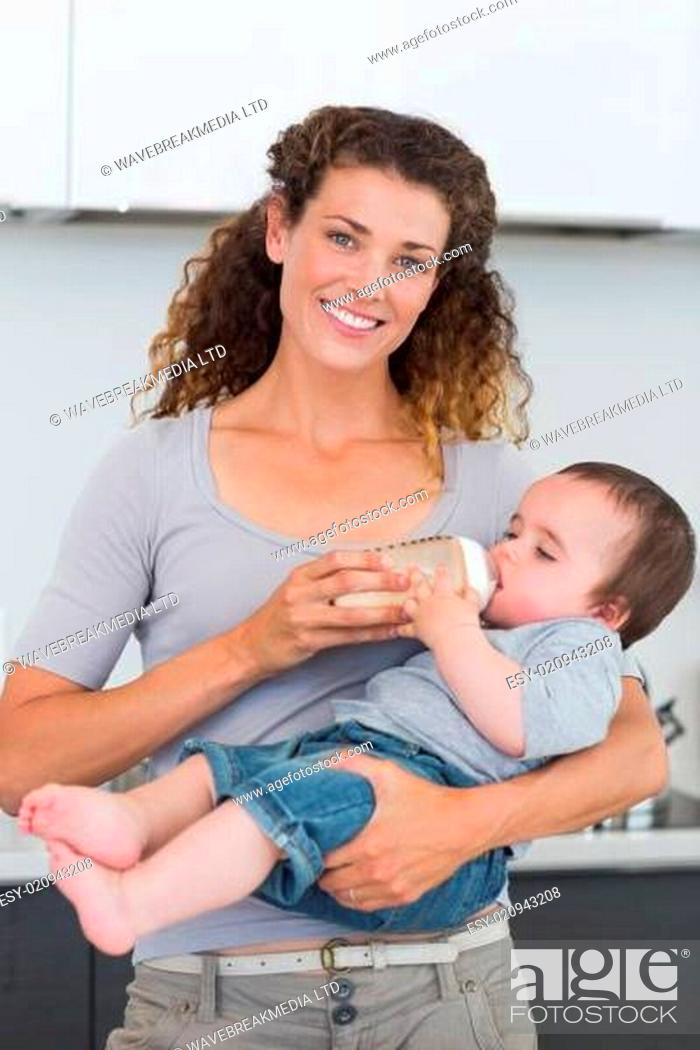 Stock Photo: Happy mother feeding milk to baby.