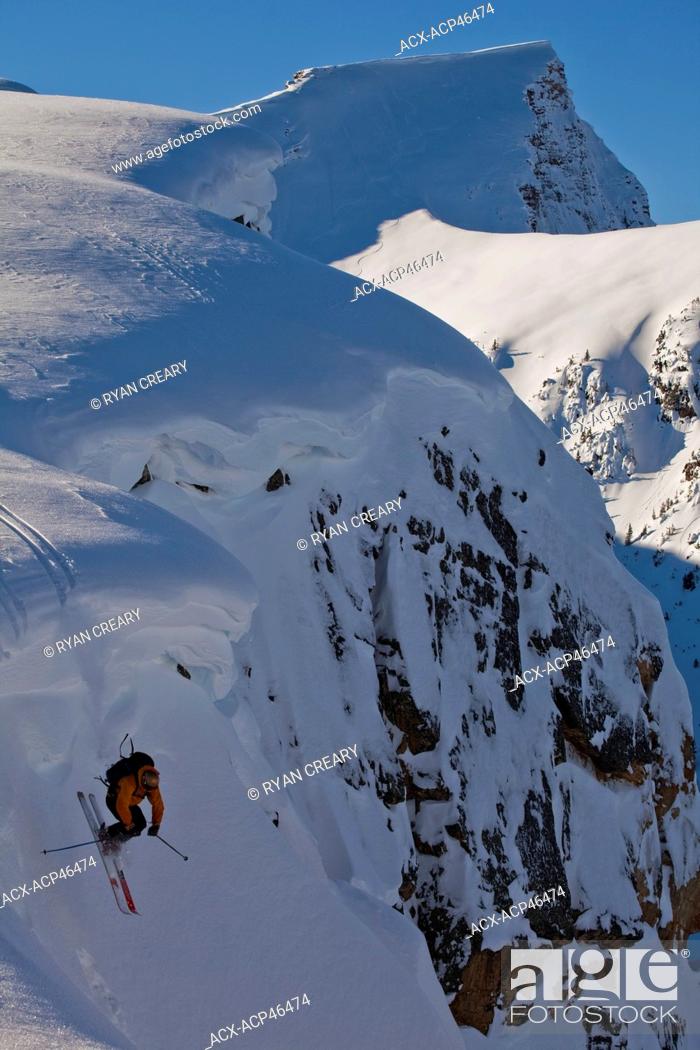 Stock Photo: A male skier drops off a cornice in the, Kicking Horse Backcountry, Golden, British Columbia, Canada.